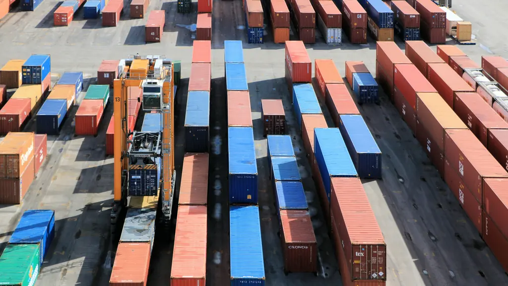 Shipping containers stacked in rows across a port container park, seen from above.