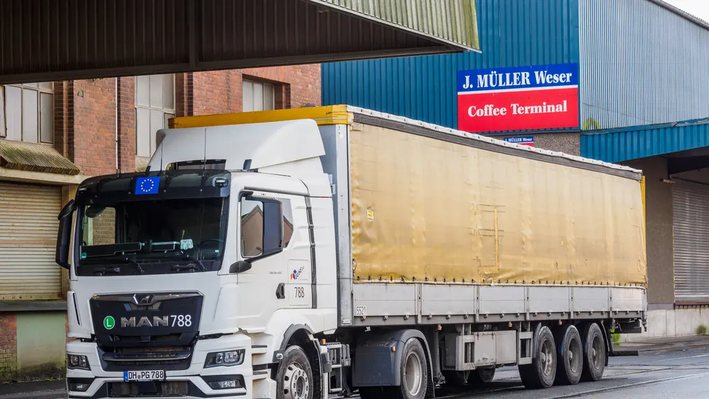 A curtainsider semi-trailer standing at a covered loading bay at a port terminal.