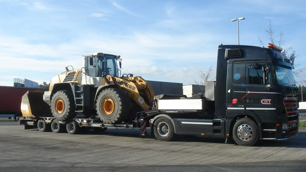 A wheel loader secured on a low-loader semi-trailer coupled to a tractor unit.