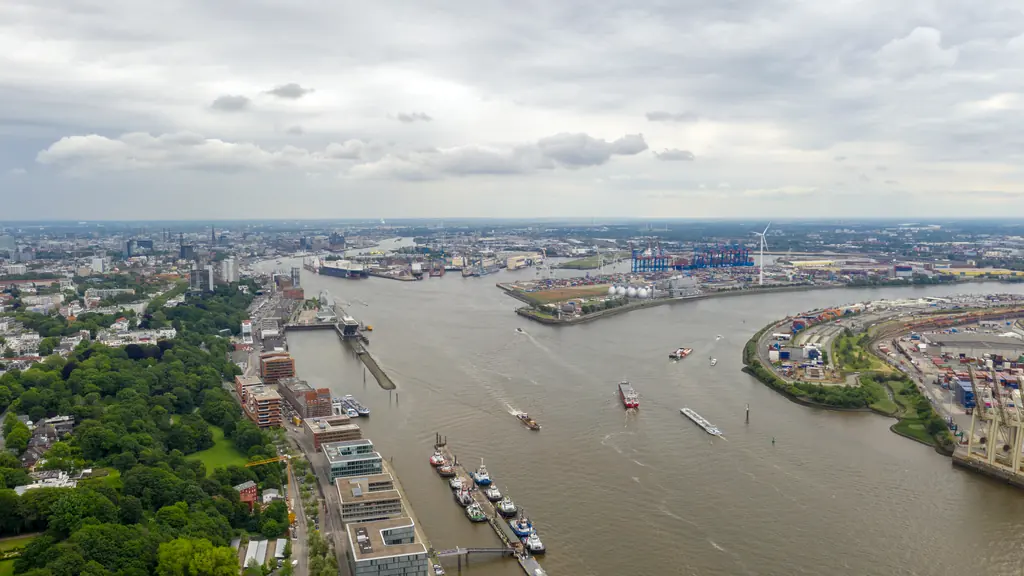 An aerial view along the River Elbe over the quays and container terminals of a major port.