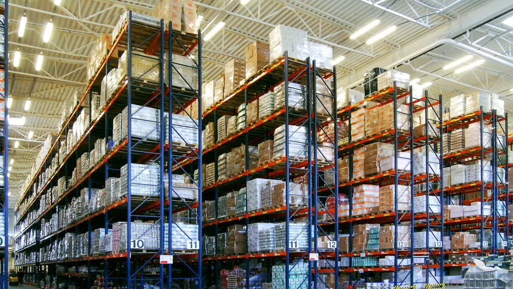 Loaded pallet racking rising several levels along the aisles of a distribution warehouse.